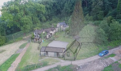 A picture showing a hand drawn architectural design overlaid onto a photograph of the site for a multi-generational home.