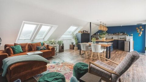 A photo of a light loft conversion showing kitchen and Velux windows